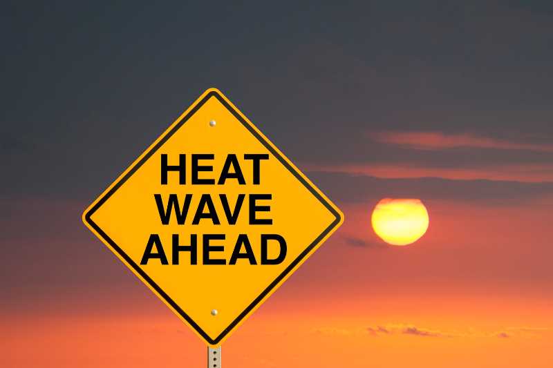 street sign that reads heat wave ahead