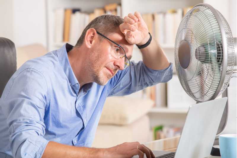 man in front of fan cooling off