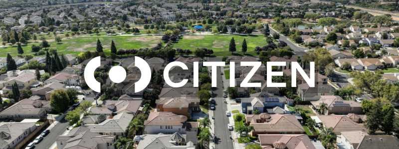 Citizen logo displayed over an aerial view of city streets in motion, symbolizing real-time public safety alerts.